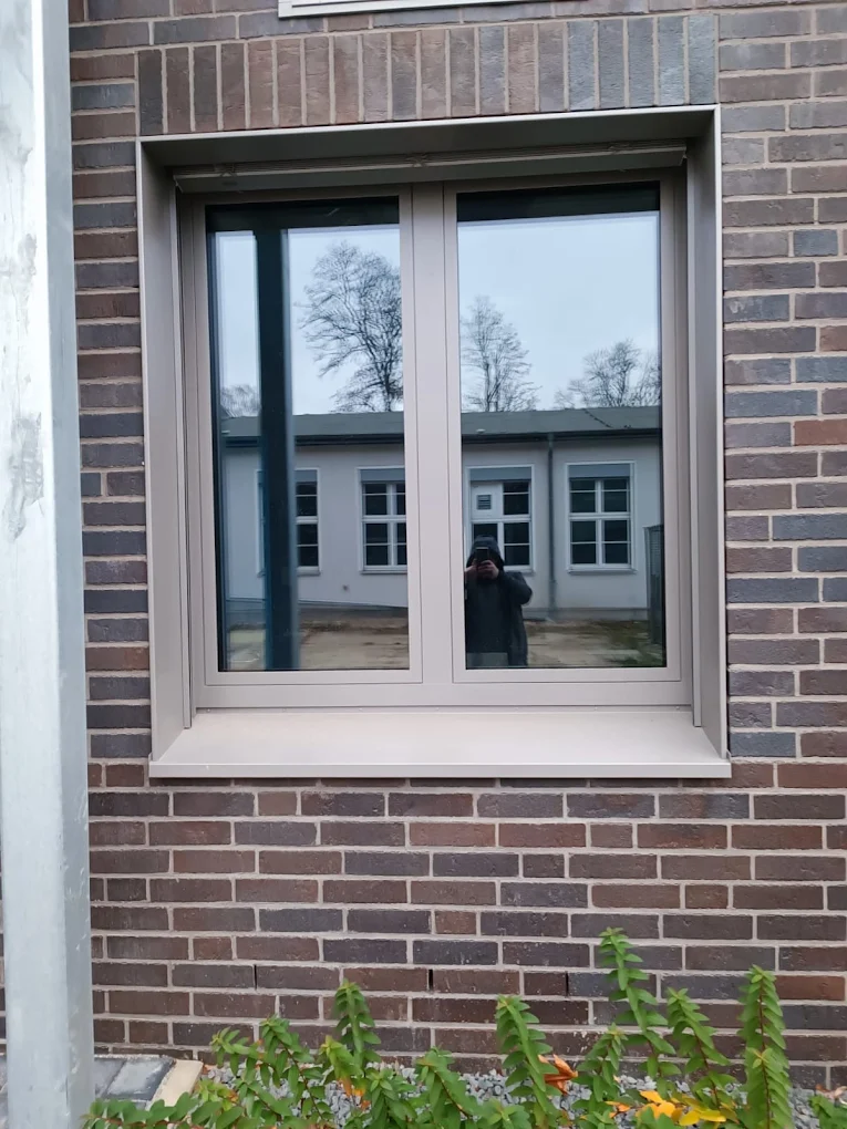 Okno aluminiowe uchylno-rozwierne na elewacji z cegły klinkierowej